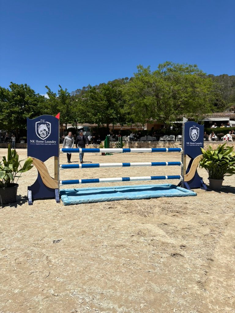 Obstáculo de salto con el escudo de NK Horse Laundry en un concurso