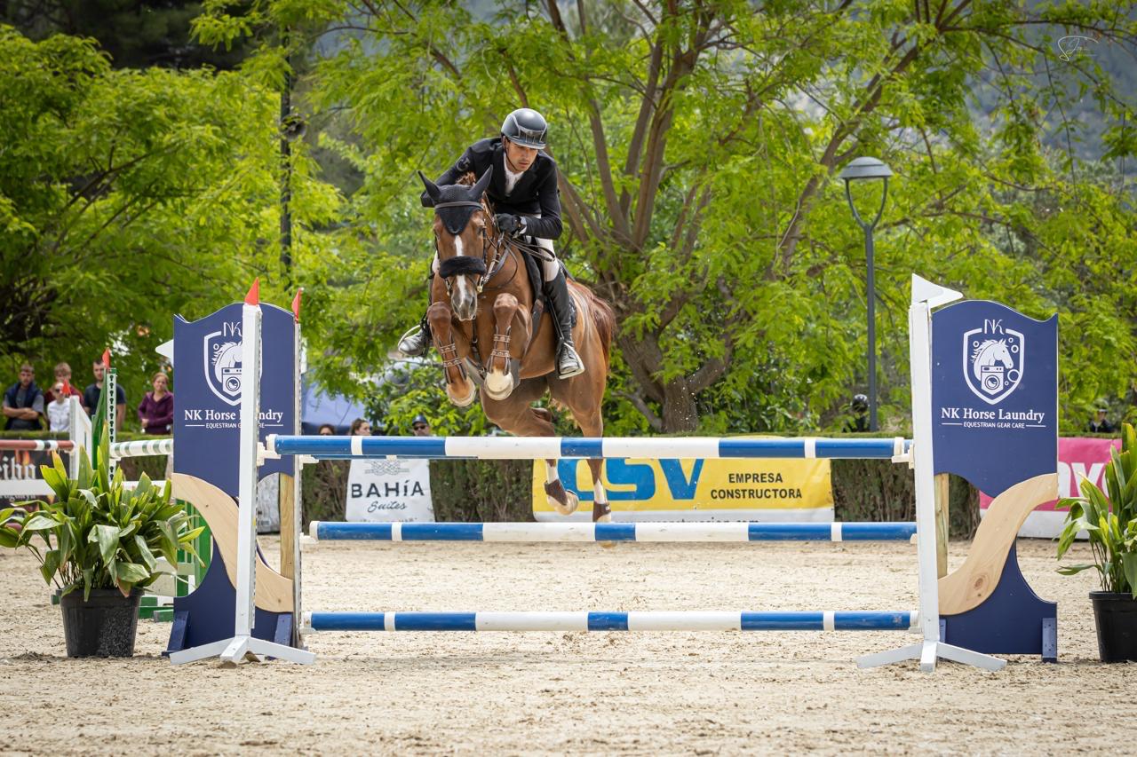 Caballo saltando un obstáculo en pista
